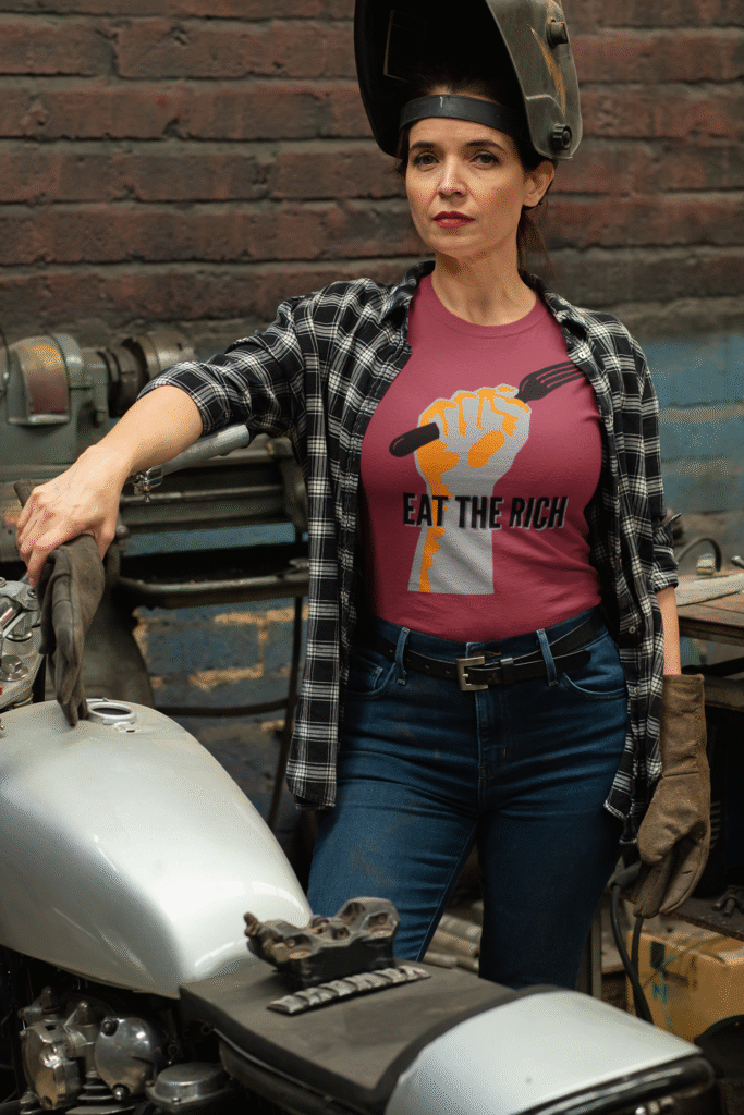 woman repairs motor cycle in Eat The Rich fork in Fist graphic T shirt Berry Colcor
